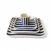 Set of blue and white striped ceramic dishes on a white background