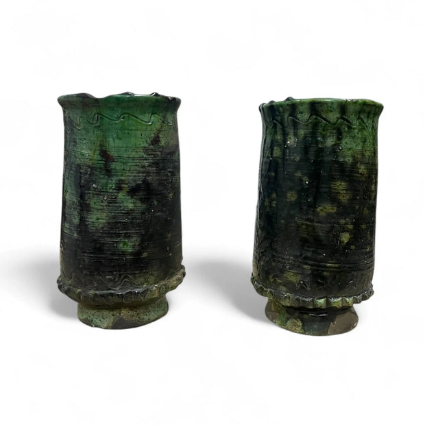 Two greenish-brown ceramic vessels on a white background
