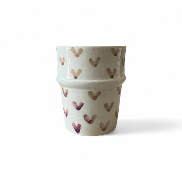Two stacked ceramic pots with heart patterns on a white background
