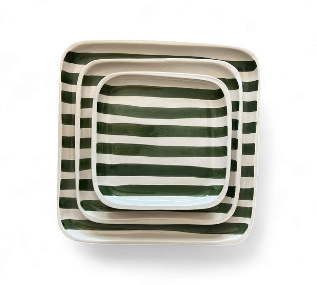 Set of three square ceramic trays with green and white striped pattern on a white background