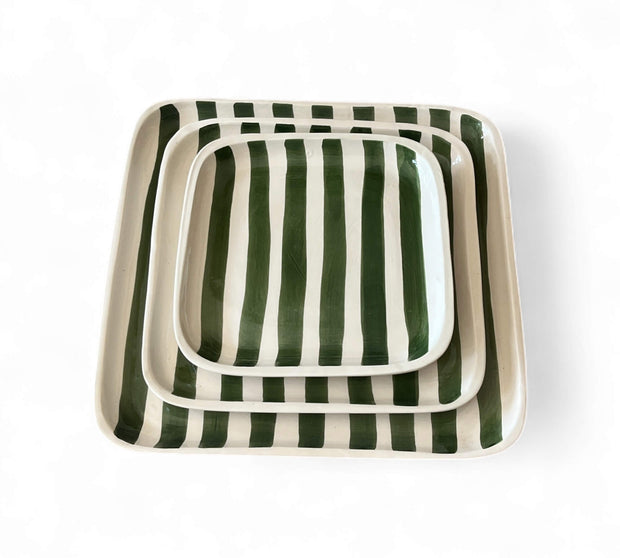 Set of three square ceramic trays with green and white striped pattern on a white background