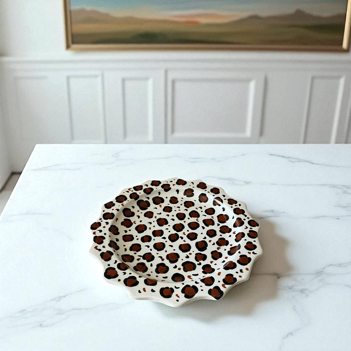Leopard print plate on a marble surface with a painting in the background
