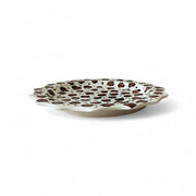 Decorative plate with brown polka dot pattern on a white background