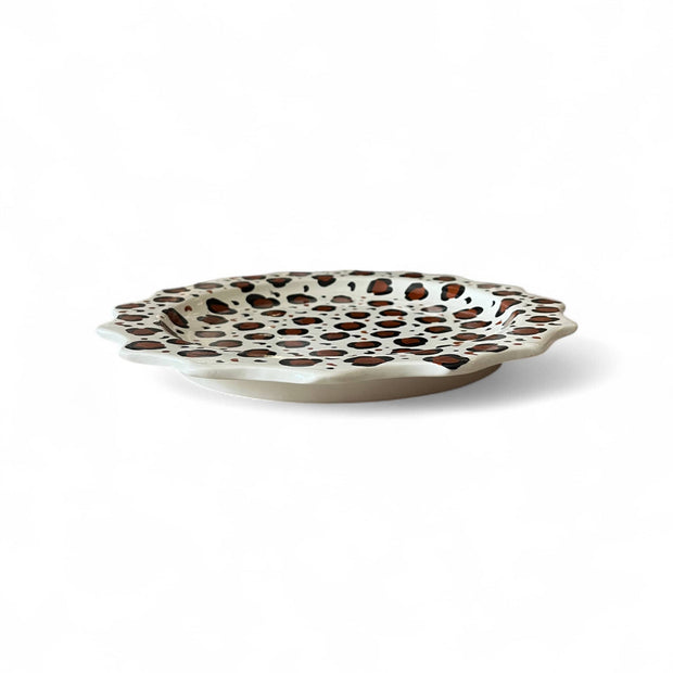 Decorative plate with brown polka dot pattern on a white background