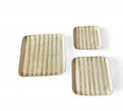 Set of three square ceramic plates with striped pattern on a white background