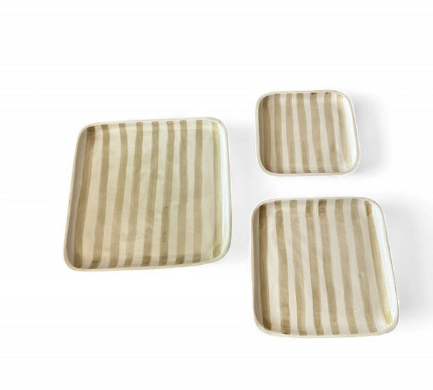 Set of three square ceramic plates with striped pattern on a white background