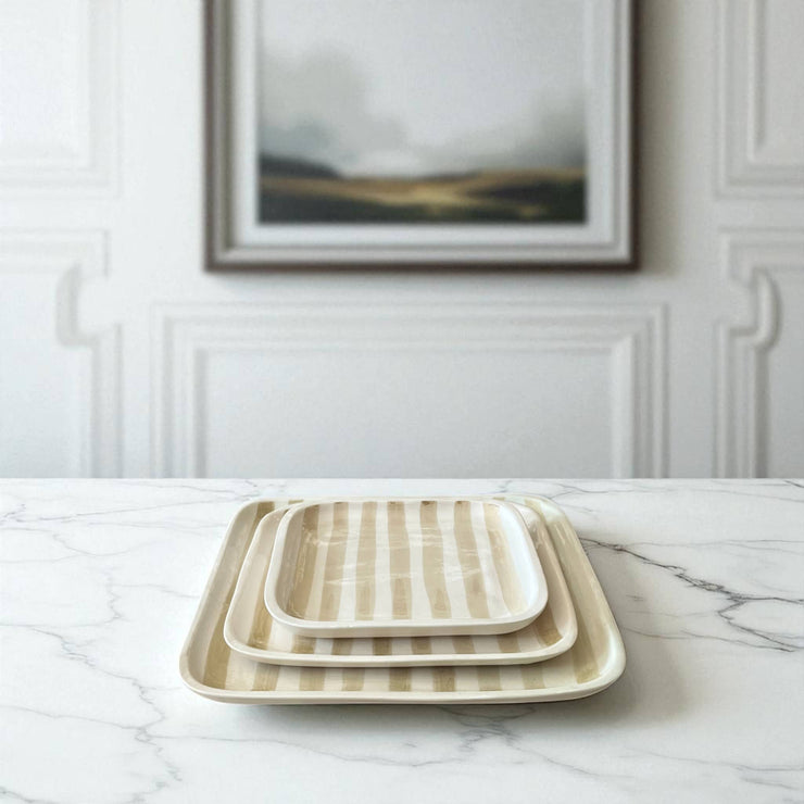 Set of three rectangular ceramic trays with striped pattern on a marble surface.