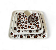 Set of ceramic dishes with leopard print pattern on a white background