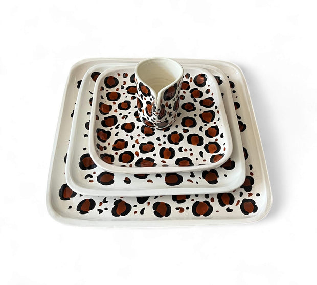 Set of ceramic dishes with leopard print pattern on a white background
