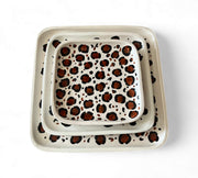 Set of two ceramic trays with leopard print design on a white background
