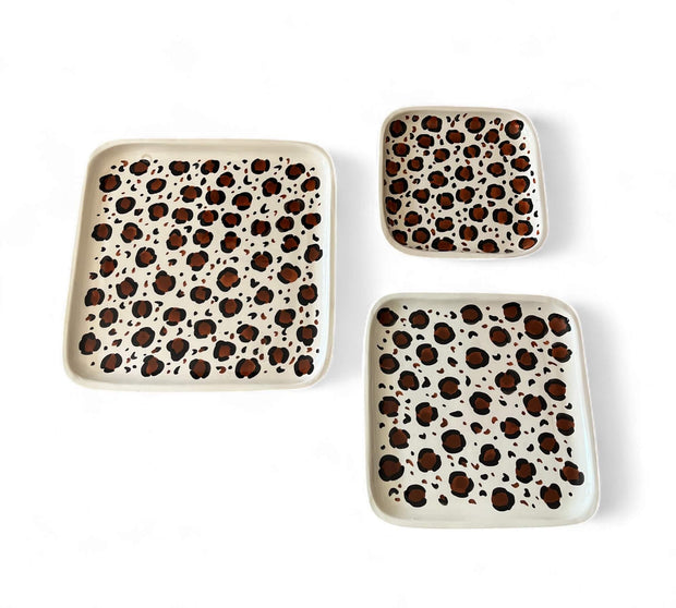 Set of three square plates with leopard print pattern on a white background