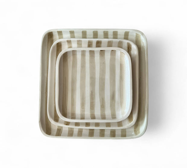 Set of three square ceramic trays with striped pattern on a white background