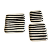 Set of three square ceramic plates with black and white stripes on a white background