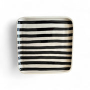 Square ceramic plate with black and white stripes on a white background