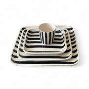Set of black and white striped ceramic dishes on a white background
