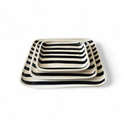 Set of three rectangular ceramic trays with black and white striped pattern on a white background
