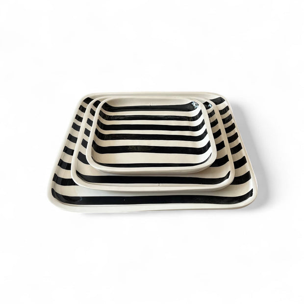 Set of three rectangular ceramic trays with black and white striped pattern on a white background