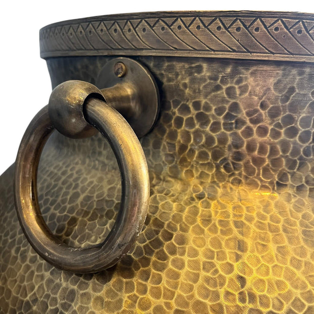 Close-up of a textured bronze Brass pot with handles with a ring handle on a white background