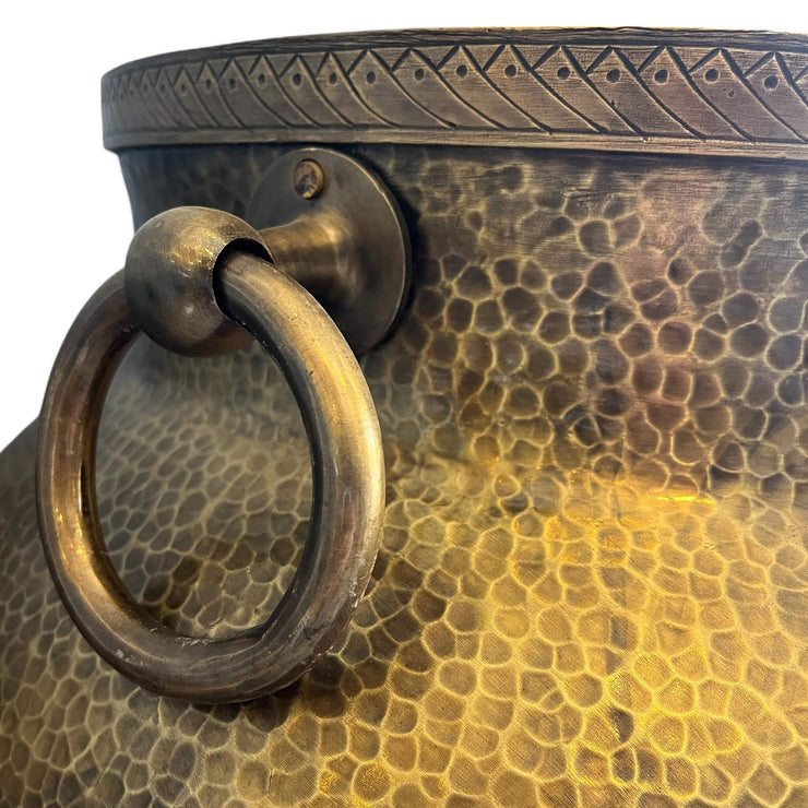 Close-up of a textured bronze Brass pot with handles with a ring handle on a white background