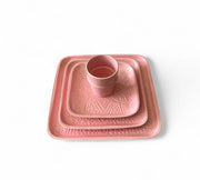 Set of pink ceramic trays with geometric patterns on a white background