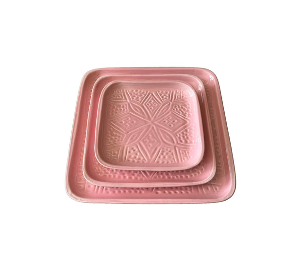 Set of two pink ceramic trays with textured design on a white background