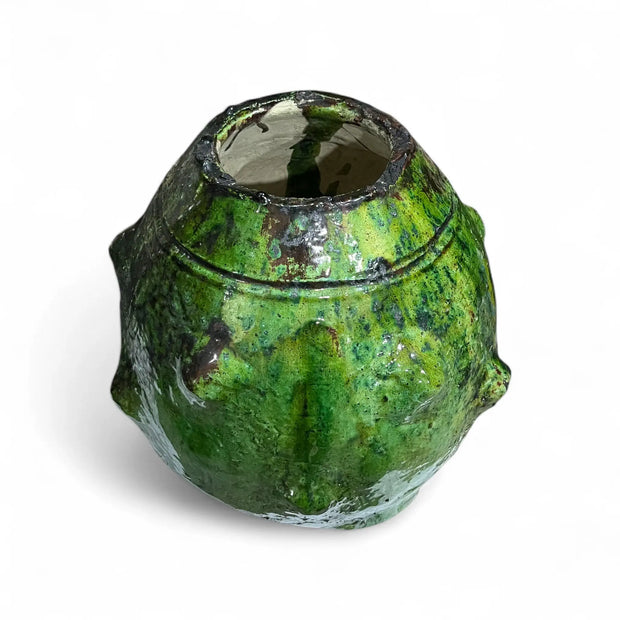 Green ceramic vase with textured surface on a white background
