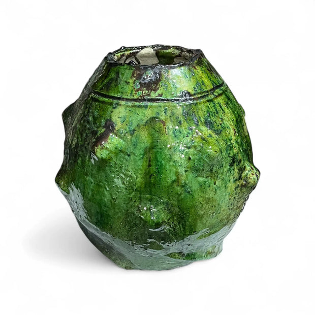 Green vase with textured surface on a white background