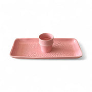 Pink ceramic tray with a matching cup on a white background