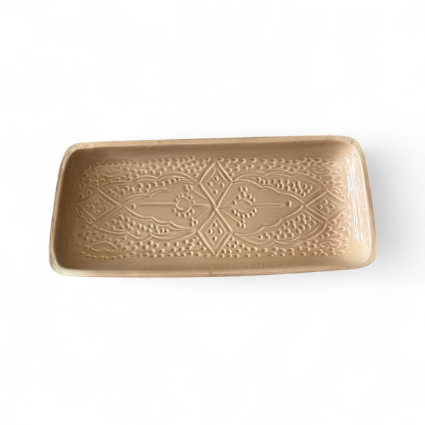 Beige ceramic tray with decorative patterns on a white background
