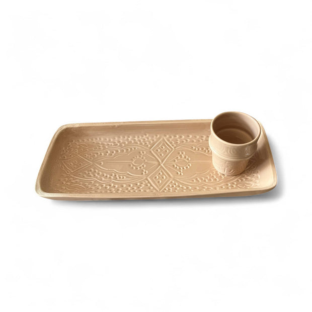 Beige ceramic tray with geometric pattern and matching cup on a white background