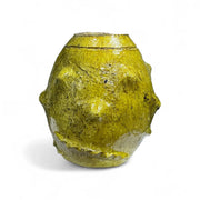 Yellow ceramic vase with textured surface on a white background