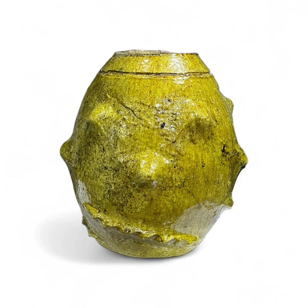Yellow ceramic vase with textured surface on a white background