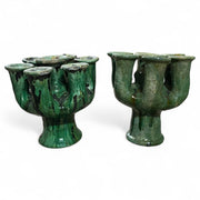 Two sets of green ceramic candle holders on a white background