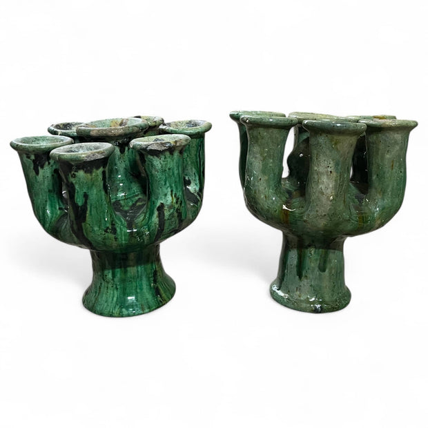 Two sets of green ceramic candle holders on a white background
