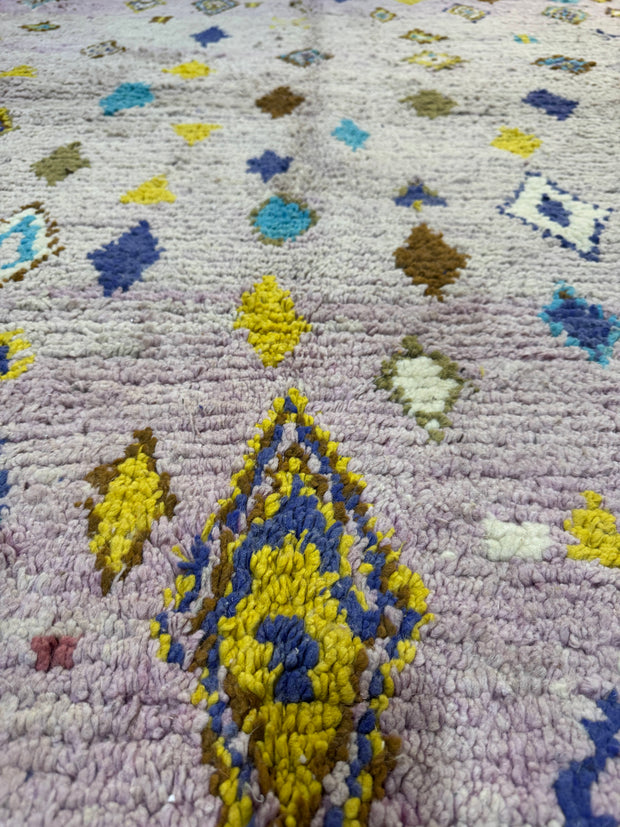 Close-up of a textured rug with geometric patterns in various colors.