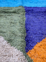 Close-up of a textured fabric with blue, orange, green, and gray colors.
