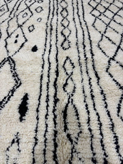 Close-up of a textured rug with black geometric patterns on a white background