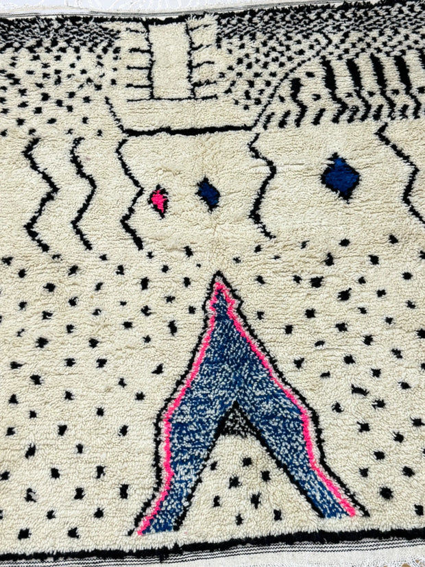 Textile art piece with abstract patterns and shapes on a beige background