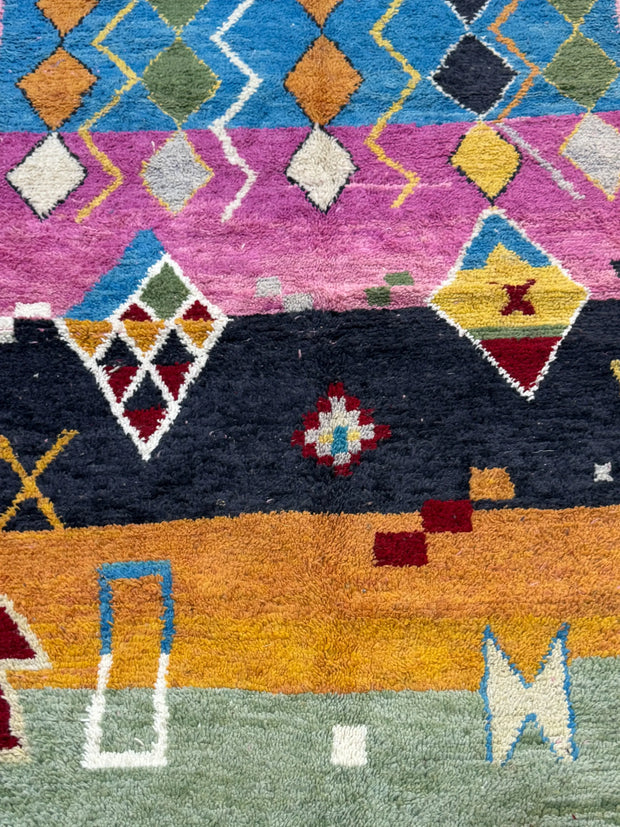 Colorful geometric patterned rug with various shapes and colors.