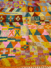 Multicolored geometric patterned rug with various shapes and colors.