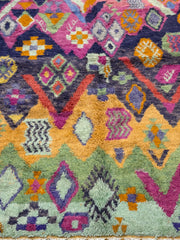Close-up of a colorful patterned rug with geometric designs.