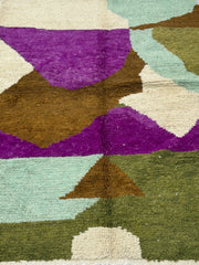 Multicolored geometric patterned rug with purple, brown, green, and beige colors.