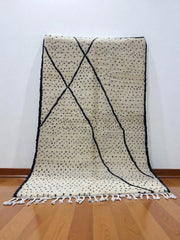 Handwoven Moroccan Azilal carpet in ivory wool with black dotted and linear patterns, 252 × 158 cm