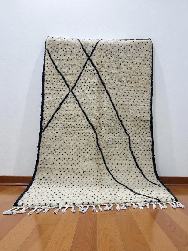 Handwoven Moroccan Azilal carpet in ivory wool with black dotted and linear patterns, 252 × 158 cm