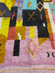 Close-up of a colorful geometric-patterned rug with various shapes and colors.