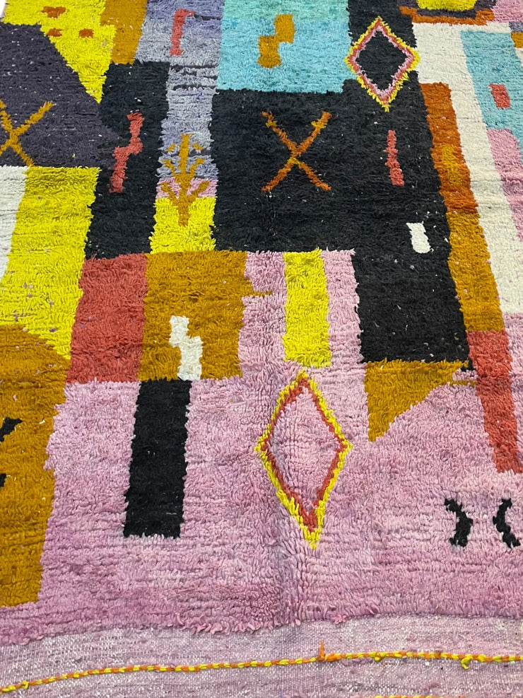 Close-up of a colorful geometric-patterned rug with various shapes and colors.