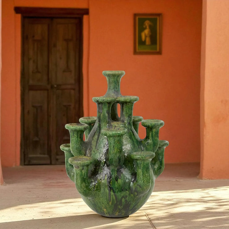 Multi-Neck Vase & Candle Holder against an orange wall with a wooden door.