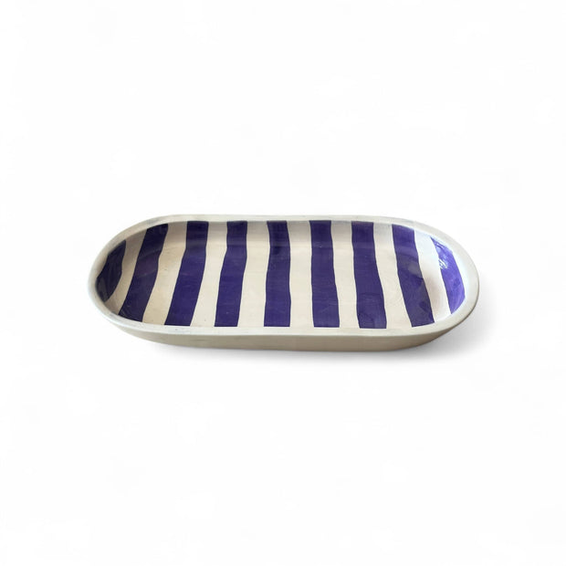 Rectangular ceramic plate with blue and white stripes on a white background