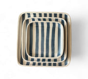 Set of three striped ceramic trays on a white background