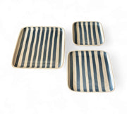 Set of three striped ceramic trays on a white background